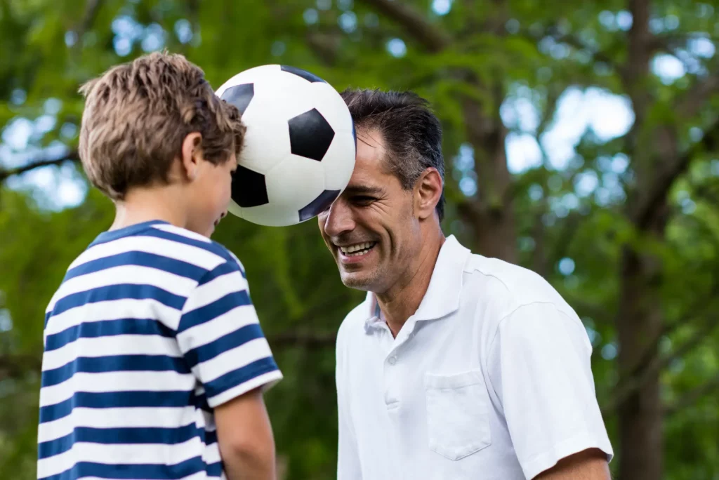 Padre e hijo jugando juntos al fútbol y divirtiéndose, Foquinha